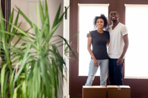 millennial couple walking into new home