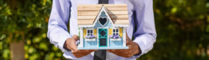 Realtor holding small model house