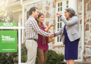 Agent giving the keys of their new house to happy couple