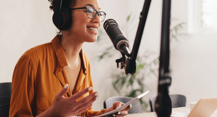 Woman talking on a microphone, recording a podcast