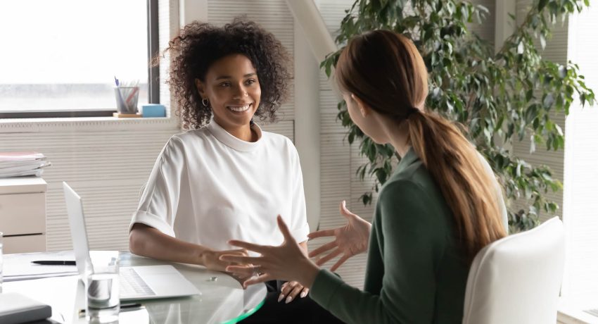 A white woman interviewing a black woman