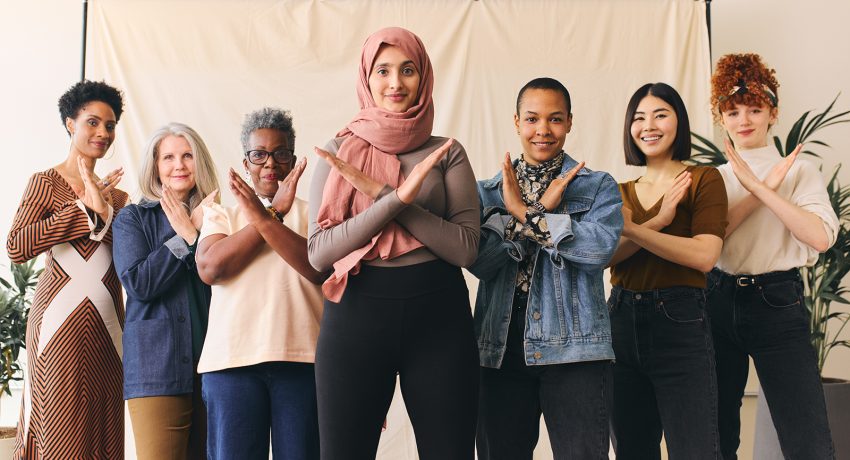 Middle Eastern woman wearing hajib gesturing Break The Bias in support of International Women's Day with female friends