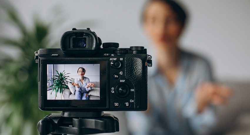 Woman recording herself with a professional camera and a tripod