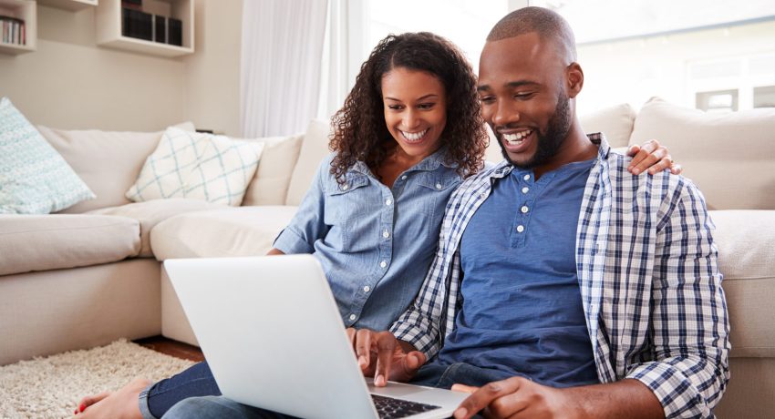 young couple looking at laptop at home