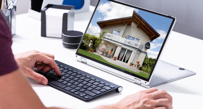 Man Selecting New House On Laptop At Home