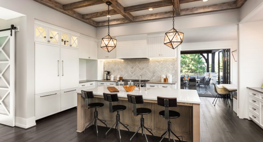 Kitchen Interior with Island, Sink, Cabinets, and Hardwood Floors in New Luxury Home